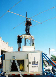 Two men assembling a radio antenna tower