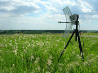 Microwave antenna on tripod in field of long grass
