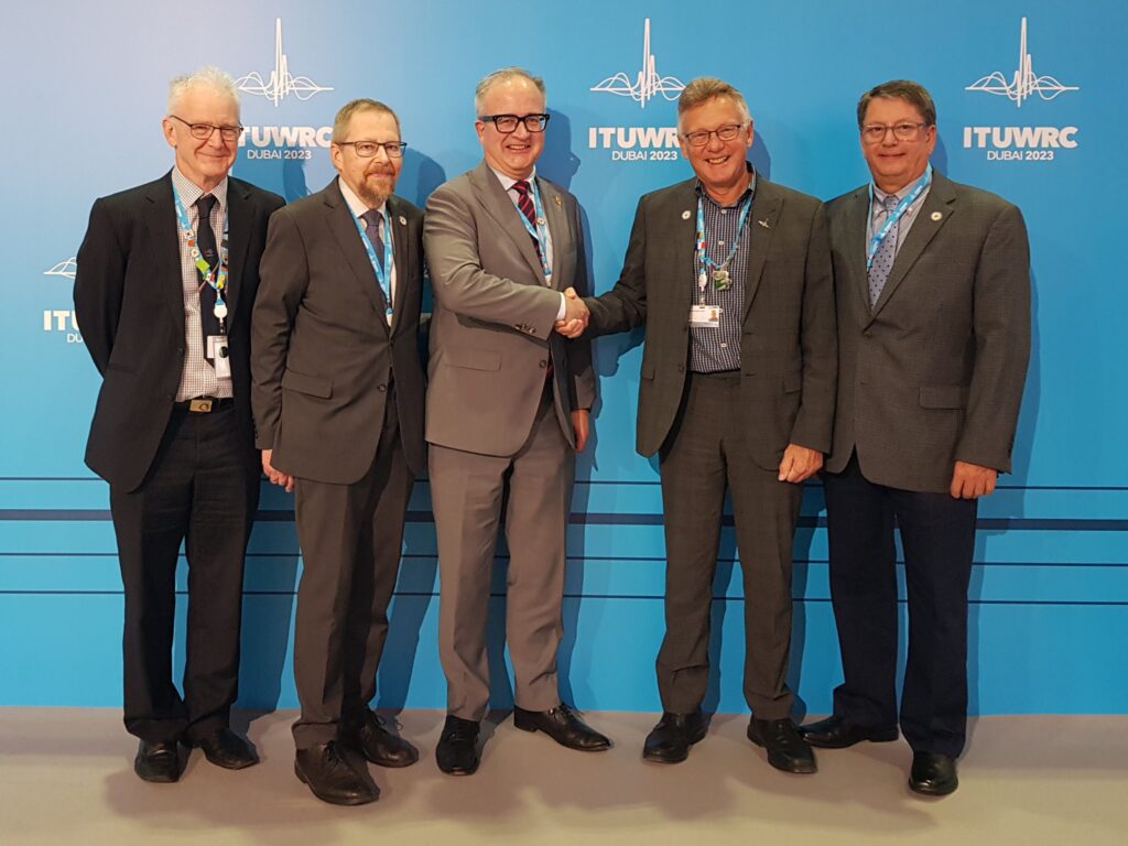 IARU President Tim Ellam, VE6SH shakes hands with Barry Lewis, G4SJH at WRC-23