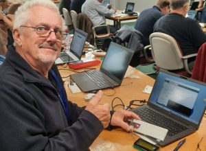 Smiling man in front of computer at MCU workshop