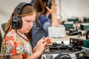 Girl wearing headphones looking at equipment in front of her