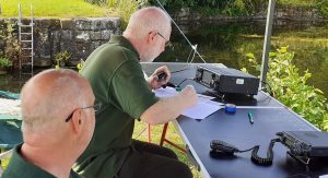 Farnborough ARS members operating the radio next to a river on a sunny day